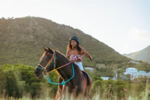Woman riding a horse at golden hour with Antigua's green hills in the background